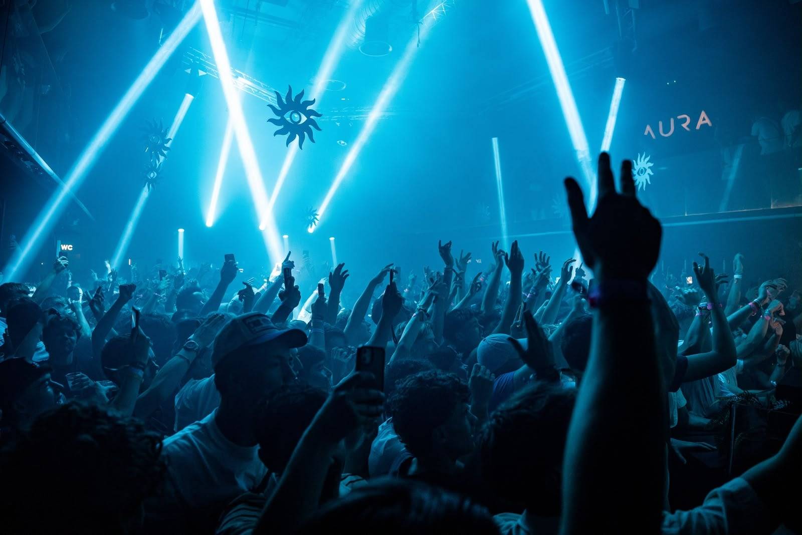 The dance floor at AURA, Laganas, under laser lights, crowd seen from behind